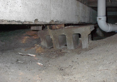 image of a sinking foundation pier under a house